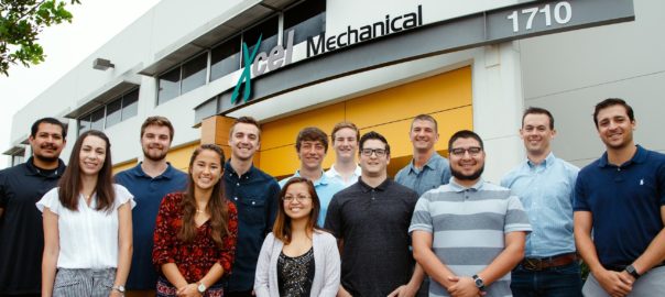 Mechanical company team posing outside building