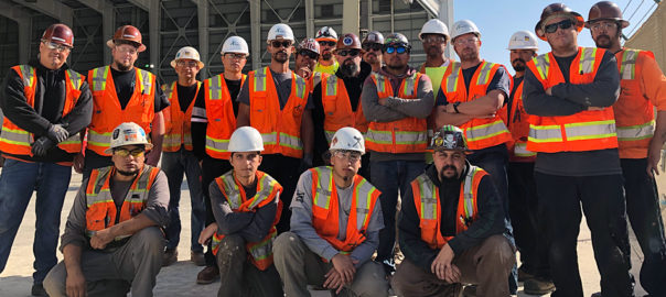 Construction workers in orange vests and hardhats
